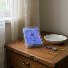 Charger l&#39;image dans la galerie, Lavender scented tartelettes de cires parfumées wax melts on wooden table with small flowers and white dish nearby
